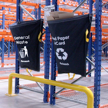 blåa återvinningssäckar vid galven på ett pallställ.